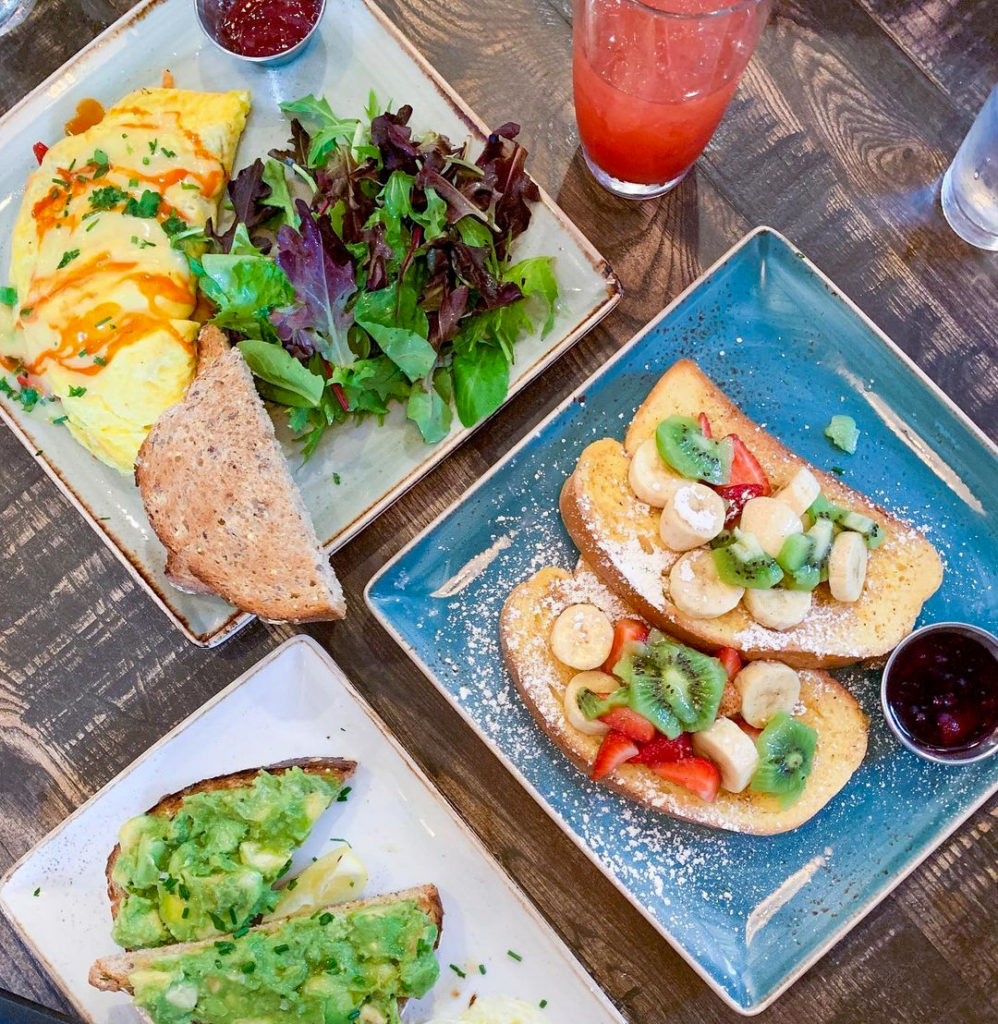 Breakfast entrees on plates with drinks