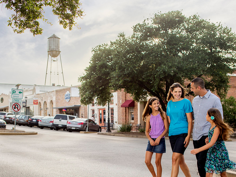 Round Rock family of 4 crossing main street in Round Rock